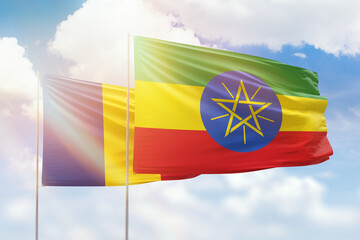 Sunny blue sky and flags of ethiopia and romania