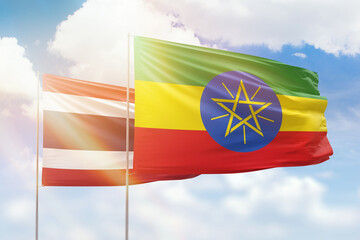 Sunny blue sky and flags of ethiopia and thailand