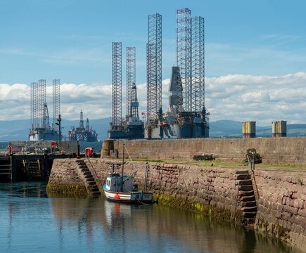 North Sea oil Rigs across an old stone harbour 