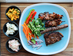 South African braai meat including lamb chops, boerewors sausage and chicken kebabs. With potato salad, coleslaw and curry pasta salad 