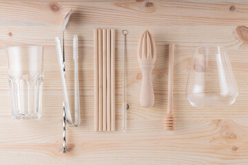 Eco friendly tools for making a cocktail. Bamboo straws, cleaning brush and wooden juicer on the...
