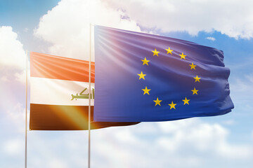 Sunny blue sky and flags of european union and iraq