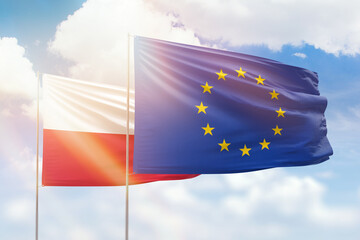 Sunny blue sky and flags of european union and poland