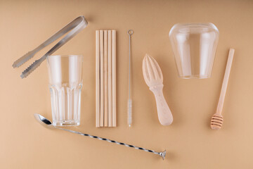 Cocktail spoon, ice tongs and glass for summer drink. Bamboo straws, cleaning brush and wooden...