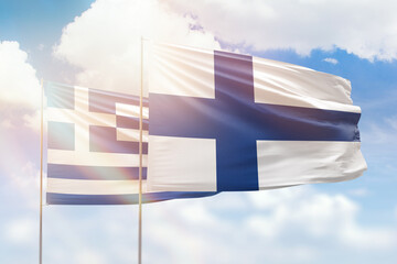 Sunny blue sky and flags of finland and greece