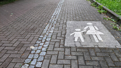 sign on the road, mother holding the child's hand