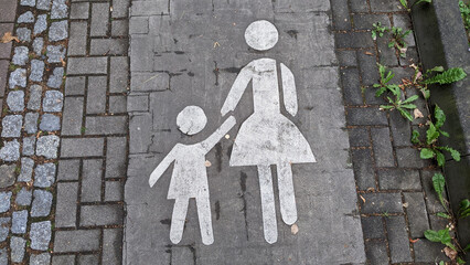 sign on the road, mother holding the child's hand