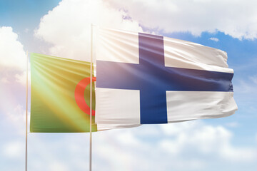 Sunny blue sky and flags of finland and algeria