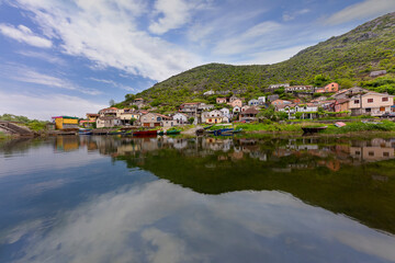 Fototapeta na wymiar Fishing village with the the reflection of the houses in the Shkoder Lake, Montenegro