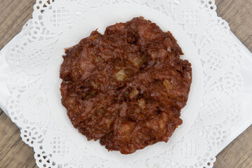 Overhead view of tempting fresh from the oven apple fritter donut from the bakery served on a plate