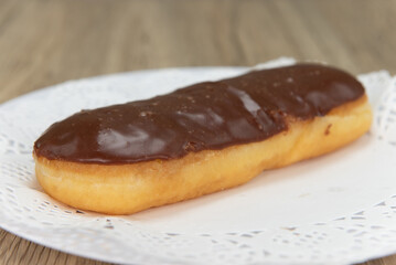 Tempting fresh from the oven chocolate bar donut from the bakery served on a plate