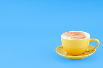 yellow cup of coffee   on blue background Space for text