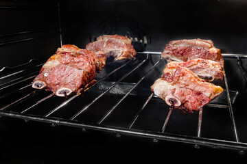 Close up: grilled beef ribs on grill plate in electric oven. Cookery, gastronomy and food concept