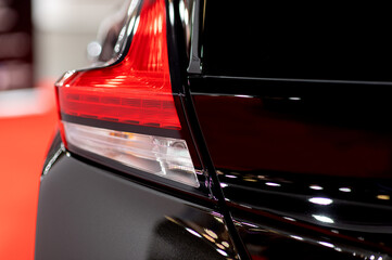 Tail light of nice and new black sport suv car in modern garage.