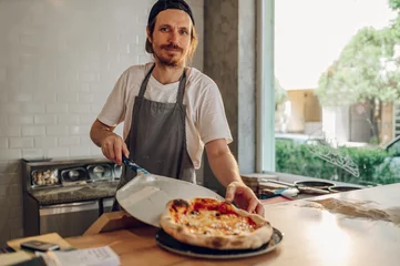 Foto auf Glas Portrait of a kitchen chef working in a pizza place © Zamrznuti tonovi