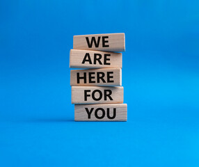 Help symbol. Wooden blocks with words 'We are here for you'. Beautiful blue background. Business and 'We are here for you' concept. Copy space.