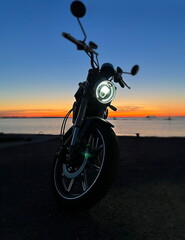   motobike on pink  suset blue dark evening sky on beach at  Baltic sea
