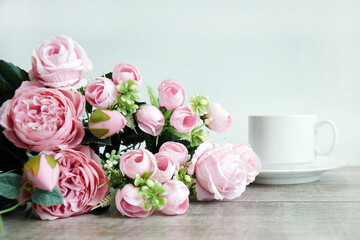 Bouquet of roses and a cup of tea on a white background