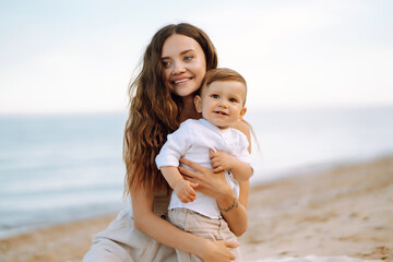 Beautiful mother and child resting on the beach.  Travel, nature, active lifestyle, resort concept. Happy childhood. 