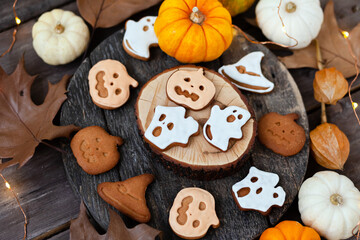 Homemade halloween holiday treats for kids. Gingerbread cookies on wooden board, decorated with pumpkins and autumn leaves. Top view