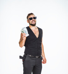 
funny brutal gangster with money in his hands. a man in the image of a gangster holds banknotes in...