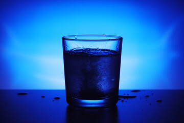 A glass with water at blue background