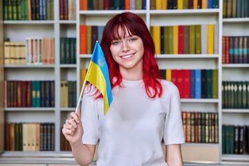 Teenage female student with flag of Ukraine in the library