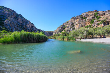 Preveli Beach - famous for the beautiful river with azure clear water and tropical palm forest behind the beach  - in southern Crete island, Greece, Europe.