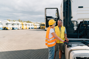 Middle age truck driver woman and man opens gas tank with keys, colleges or mechanic worker 