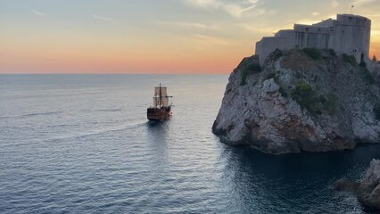 Pirate galleon ship sailing the Dubrovnik harbor at sunset