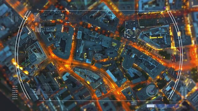 Top down shot of buildings and illuminated streets in urban borough in evening. Augmented reality showing additional info for targeted objects. Frankfurt am Main, Germany