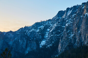 Soft morning light over snowy cliffs and mountains at Yosemite