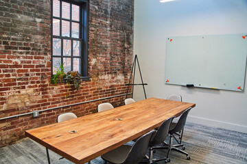 Modern office meeting room with wood table and brick wall