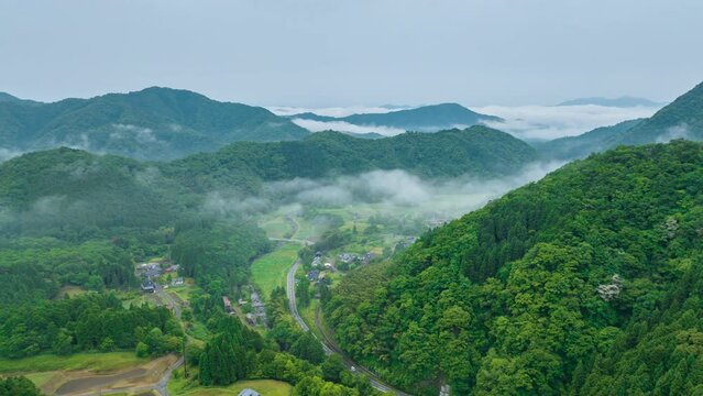 Early morning fog clears over small farms in rural mountain village