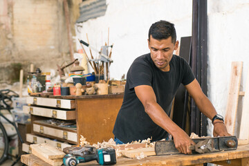 Work: Latin American worker in his workshop using different tools. Local carpentry of the town and...