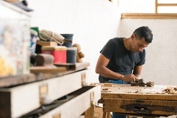 Work carpentry: Latin American worker in his workshop using different tools. Wood craftsman...