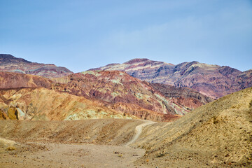 Fototapeta premium Path into Death Valley desert mountains with colorful patches