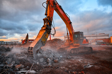 Excavator with concrete crusher on rig at demolition site