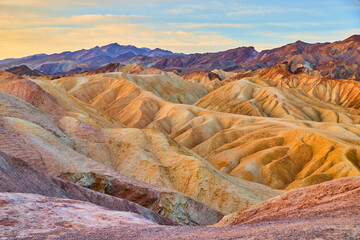 Stunning sunrise at Zabriskie Point in Death Valley with colorful sediment formations - obrazy, fototapety, plakaty