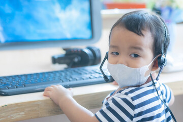 Baby Boy wearing facemask and headphone Playing Computer acting like call center officer or operator