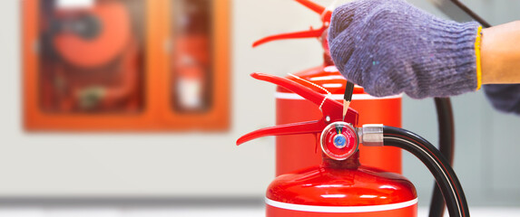Fire extinguisher has hand engineer inspection checking pressure gauges to prepare fire equipment for protection and prevent emergency and safety rescue and alarm system training concept.