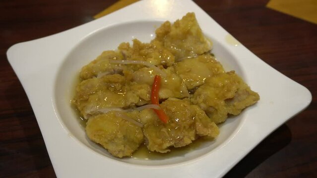 closeup of a chaufa rice dish with chijaukay chicken, typical peruvian food in a chifa chinese restaurant at night in 4k