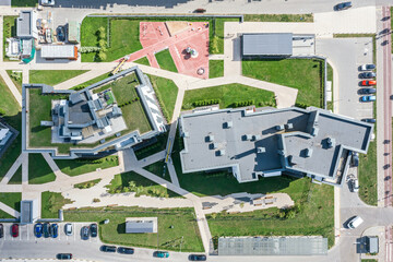 aerial top view of homes in residential community on a sunny day. green roof and playground in courtyard.