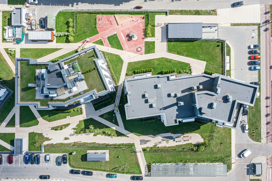 Aerial Top View Of Homes In Residential Community On A Sunny Day. Green Roof And Playground In Courtyard.