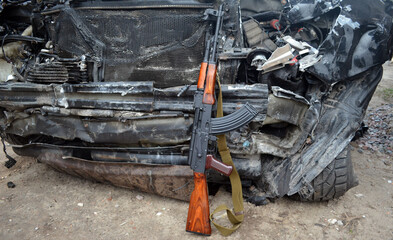 AKM(Avtomat Kalashnikova) version of Kalashnikov assault rifle and car wreck. Ukraine