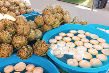 artichokes with petals and peeled in water on the market. Delicacy and organic healthy food. Vegan ingredient and antioxidant diet