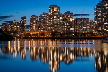 Fototapeta na wymiar Urban city night, Vancouver twilight skyline. Buildings lights reflection on False Creek water. British Columbia, Canada.