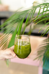 Female hand holding iced matcha. Fresh summer cocktail