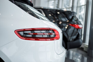 Detail on the rear light of a car. Car detail. Developed Car's rear brake light. The car is in the showroom. Automotive concept. Classic white color. The car is in the showroom. LED light
