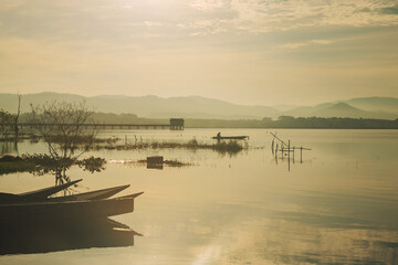 Silhouette fisherman on boat fishing in bang phra at sunrise